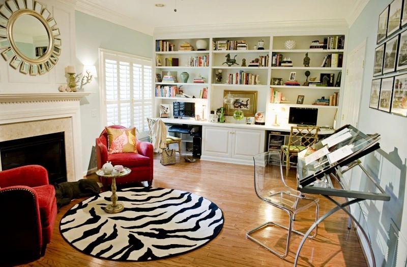 Home office with zebra rug and red accent chairs